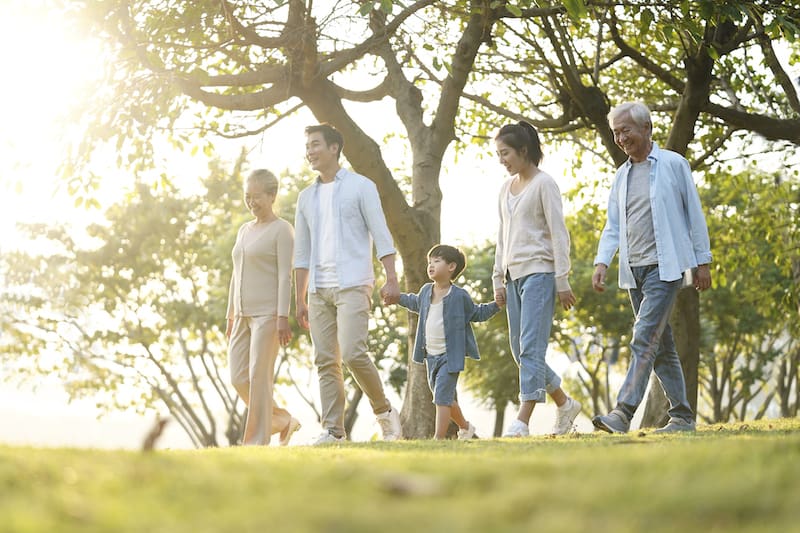 three generation family walking outdoors in park