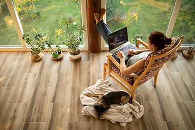 Woman sitting on her terrace and using laptop for work