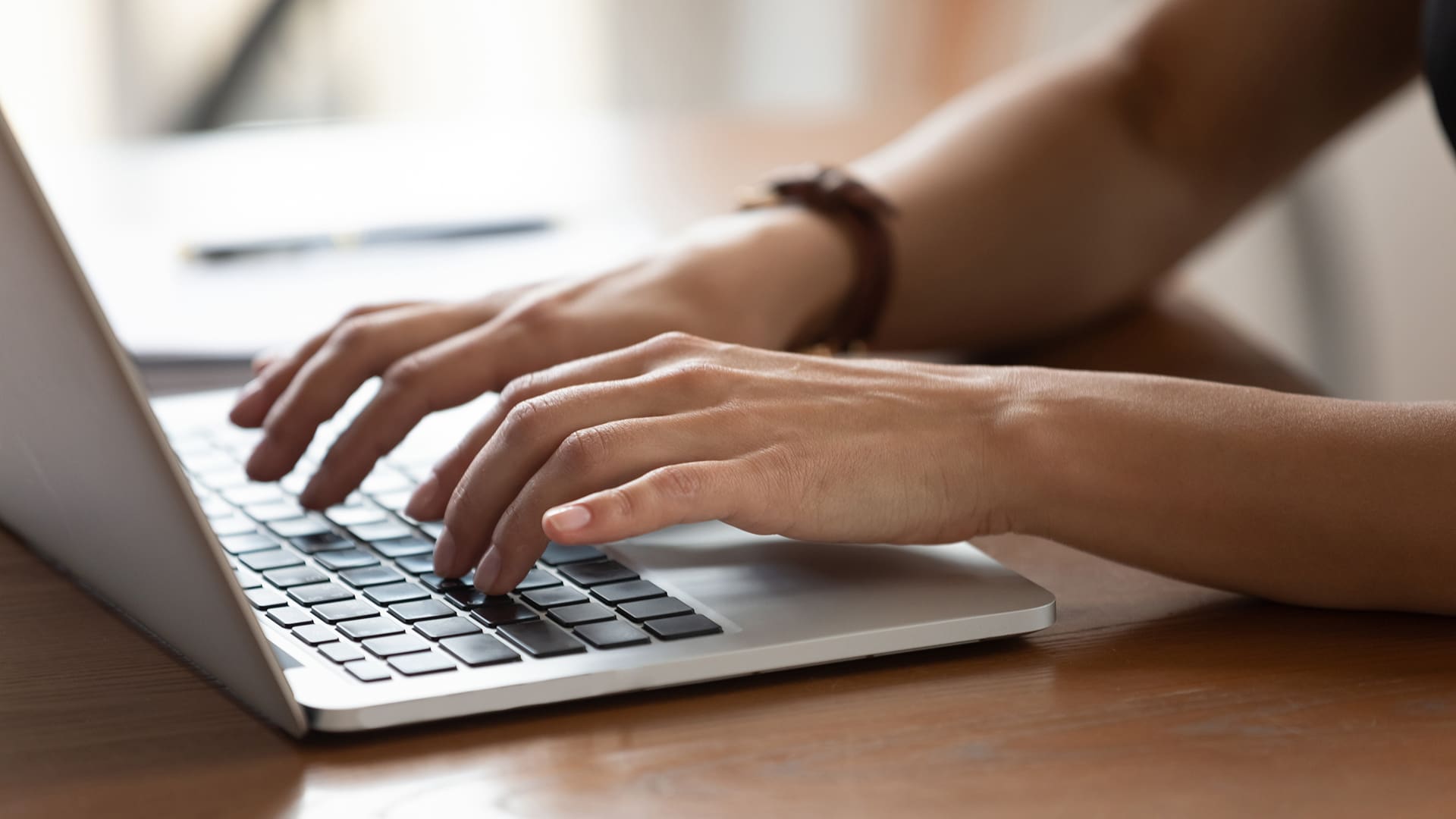 Close up of hands typing on a laptop keyboard