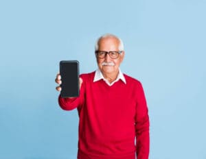 a senior showing off his phone as a result of our top SMS text strategies for senior living