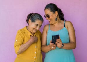 a daughter shows her mother a tremendous Senior Living Website Design on her phone