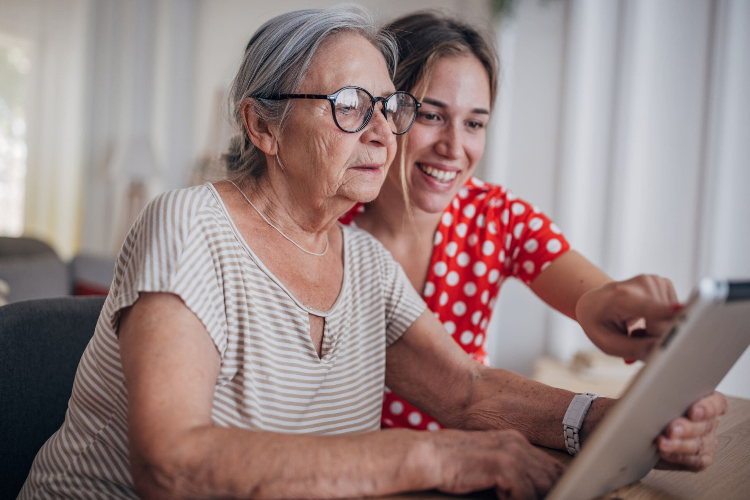 senior woman and daughter search for senior living referral sources on computer