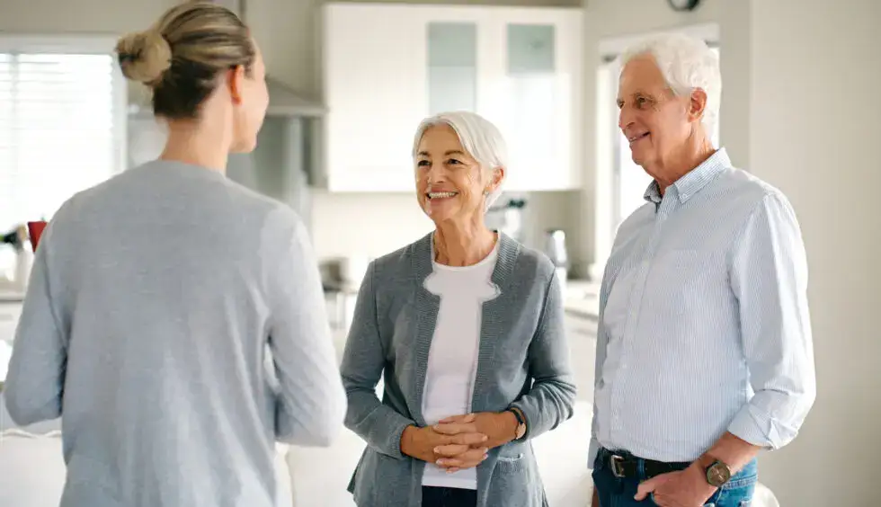 Senior couple and senior living sales person take a tour inside a senior living apartment. The sales person uses senior living sales tips to help inform, educate and motivate the couple.